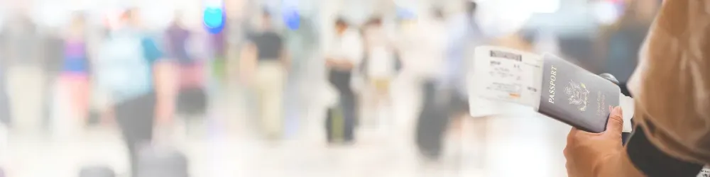 Closeup of girl holding passports and boarding pass at airport , panorama